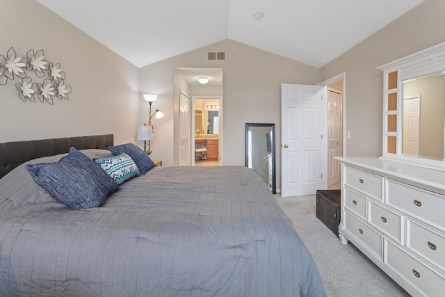 bedroom with lofted ceiling, light colored carpet, visible vents, and connected bathroom