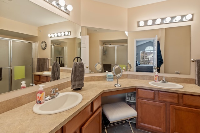 full bath with double vanity, a stall shower, ensuite bathroom, and a sink