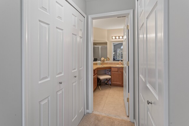 hallway featuring light carpet and light tile patterned flooring