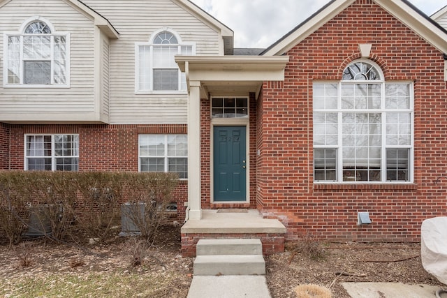 doorway to property featuring brick siding