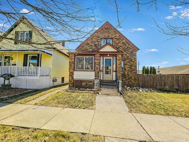 view of front of home featuring brick siding, a porch, and fence