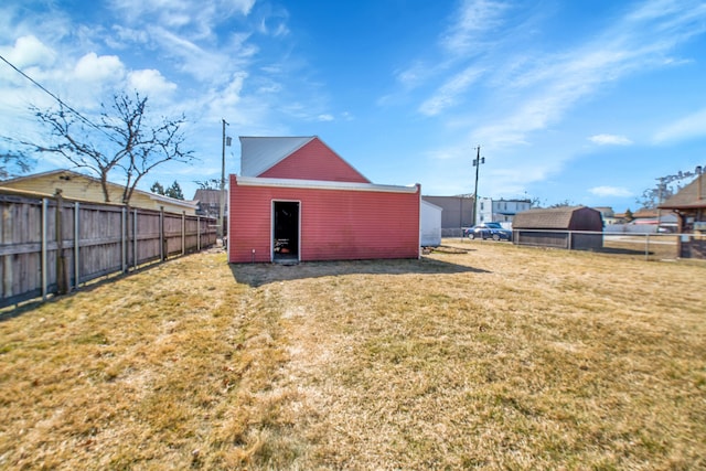 view of yard with an outdoor structure, a pole building, and fence