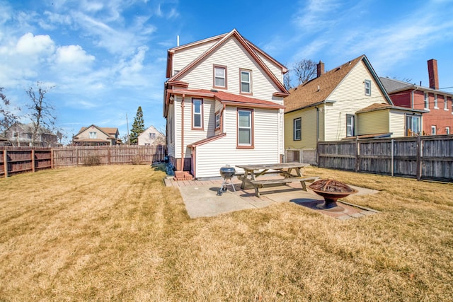 back of house with a patio, a lawn, a fire pit, and a fenced backyard