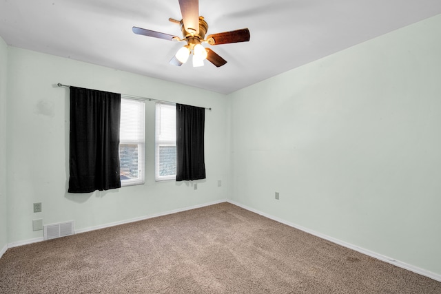 empty room with a ceiling fan, carpet, visible vents, and baseboards