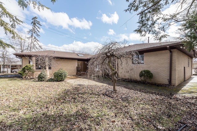 back of house with brick siding and a patio area