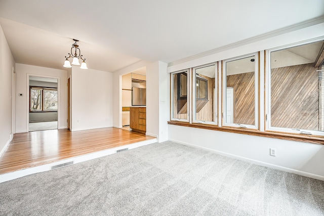 unfurnished room featuring visible vents, baseboards, and carpet