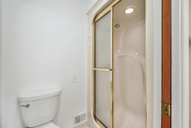 bathroom featuring a shower stall and toilet