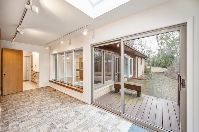 sunroom / solarium featuring track lighting, a skylight, and visible vents