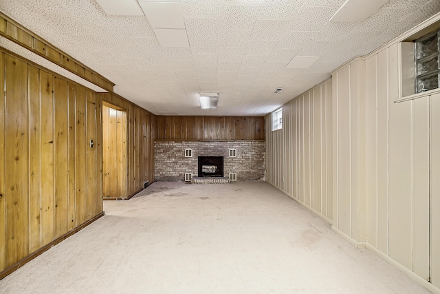 basement with carpet, wood walls, and a fireplace