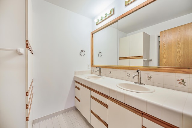 bathroom with a sink, decorative backsplash, double vanity, and tile patterned floors