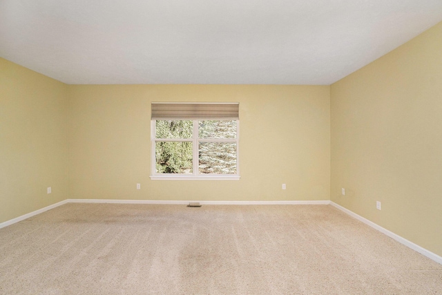 unfurnished room featuring baseboards, light carpet, and visible vents