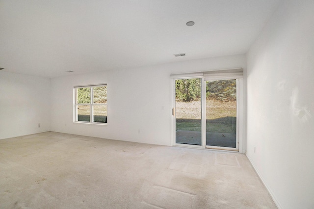 unfurnished room with visible vents and carpet flooring