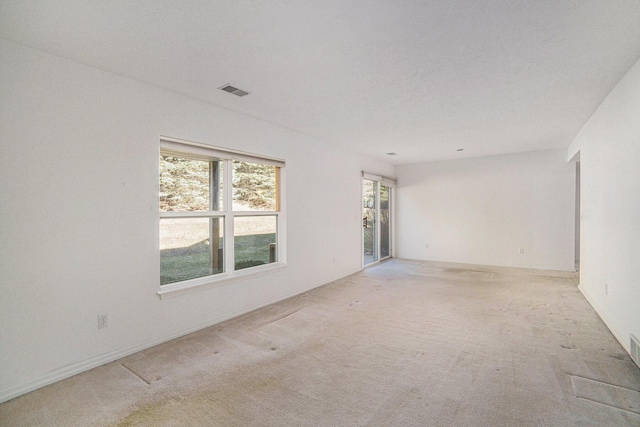 unfurnished room with light colored carpet and visible vents