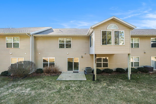 rear view of property with a patio, central air condition unit, a lawn, and a shingled roof