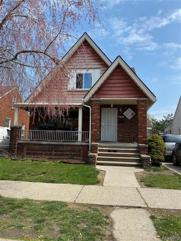 bungalow-style house with a porch and brick siding