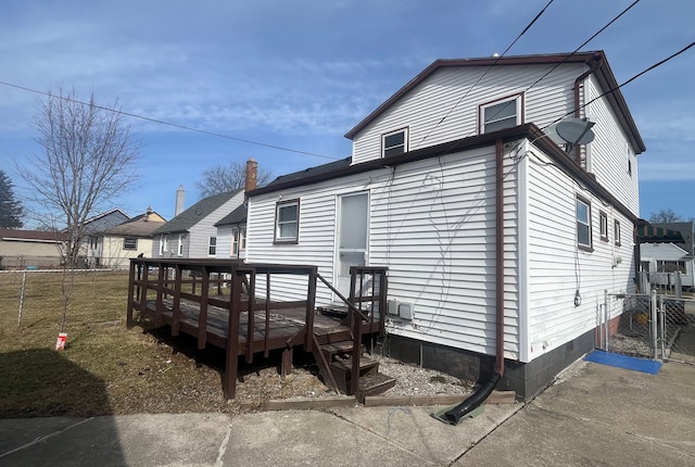 back of property featuring a wooden deck and fence