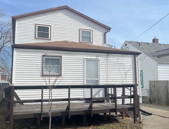 back of property with a deck and fence