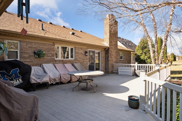 wooden terrace with area for grilling and an outdoor hangout area