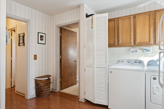 laundry area featuring washer and dryer, cabinet space, and dark wood-style flooring