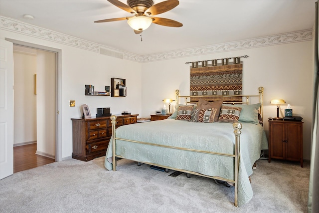 bedroom featuring a ceiling fan, visible vents, and carpet floors