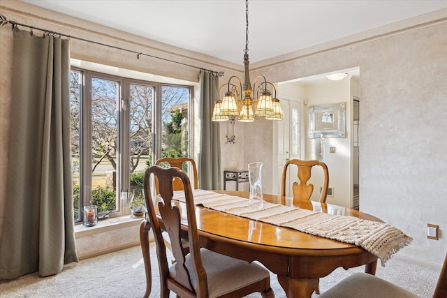 dining area featuring baseboards, a chandelier, and carpet flooring