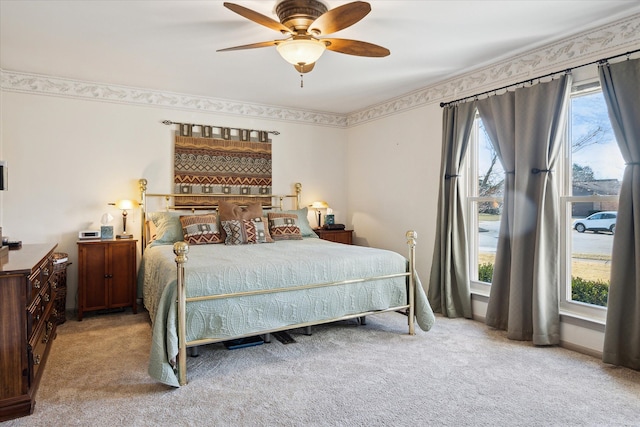 carpeted bedroom featuring baseboards, multiple windows, and ceiling fan