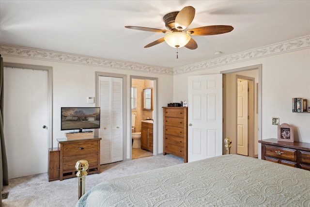 bedroom with light colored carpet, a ceiling fan, and connected bathroom