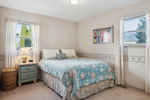 bedroom featuring light colored carpet and multiple windows