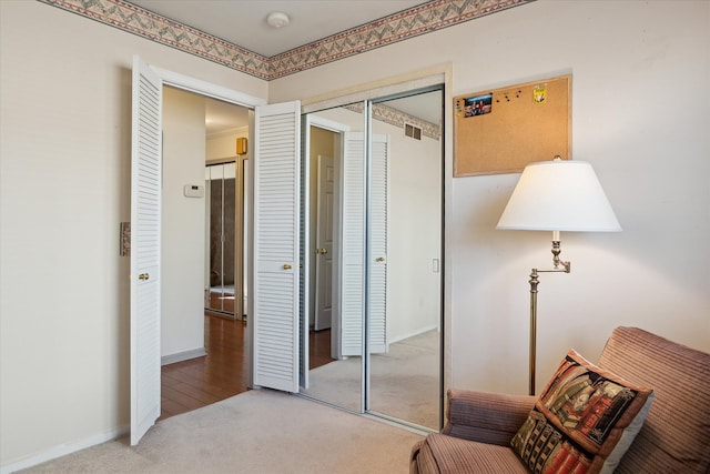 living area with visible vents, baseboards, and carpet flooring