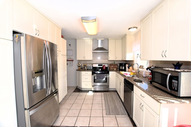 kitchen with light tile patterned flooring, a sink, stainless steel appliances, wall chimney range hood, and tasteful backsplash