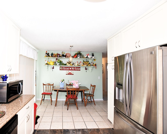 kitchen with light stone counters, light tile patterned floors, baseboards, stainless steel appliances, and white cabinets