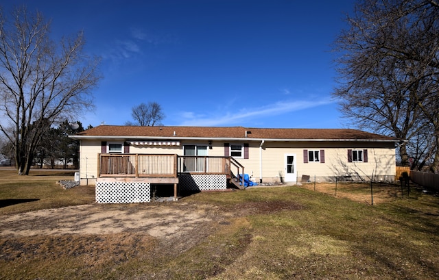 rear view of property with a lawn, a wooden deck, and fence