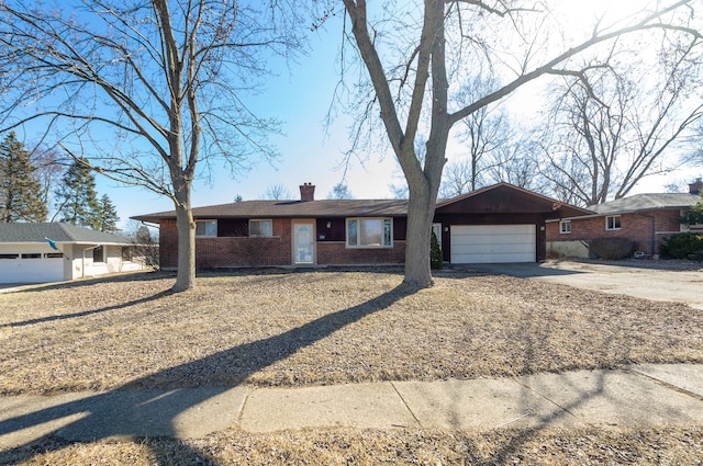 single story home with brick siding, concrete driveway, a chimney, and a garage