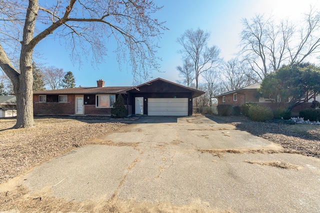 single story home featuring aphalt driveway, an attached garage, brick siding, and a chimney