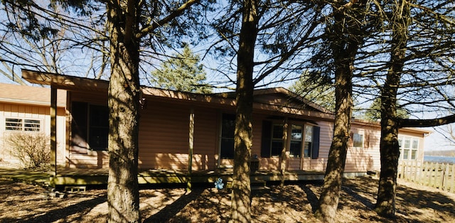 view of side of property featuring a porch and fence