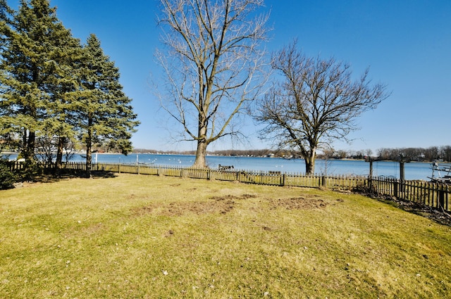 view of yard featuring a water view and fence