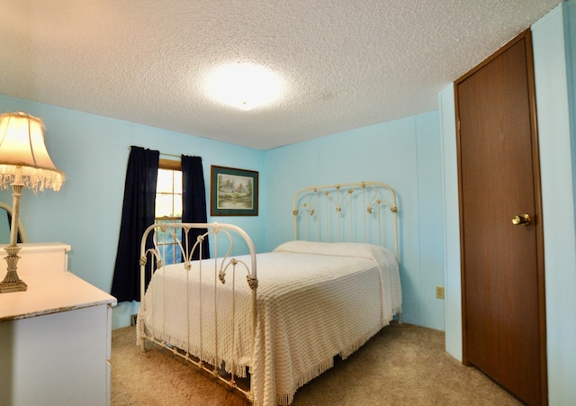 bedroom with light colored carpet and a textured ceiling