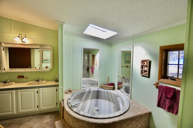 bathroom with a textured ceiling, a skylight, ornamental molding, and a sink