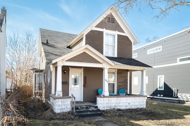 traditional-style home featuring a porch and a shingled roof