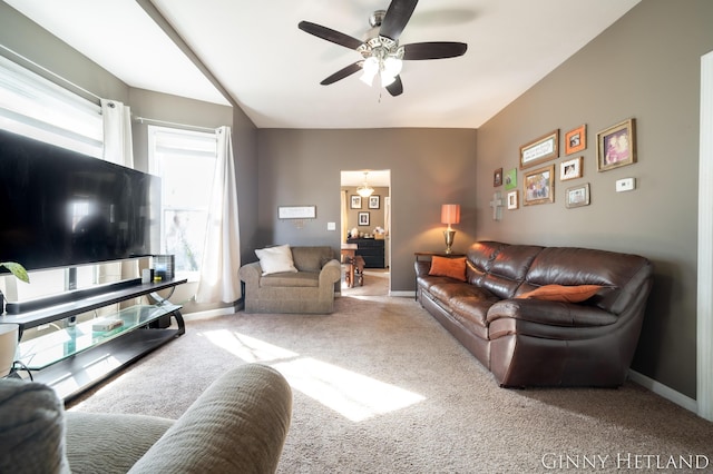 carpeted living area featuring baseboards and a ceiling fan