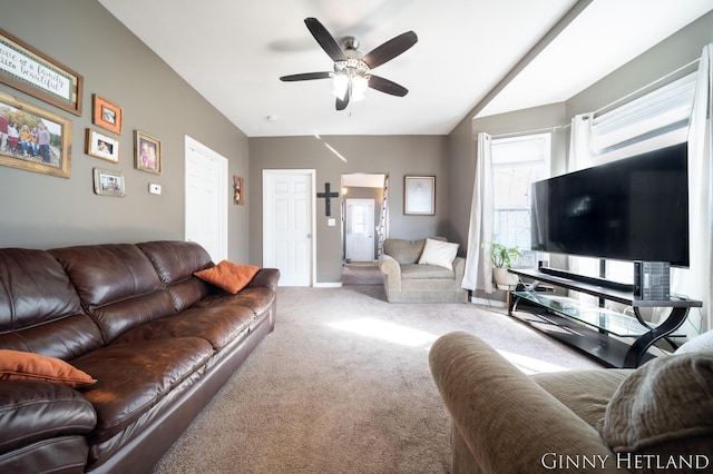 living area featuring carpet floors, a ceiling fan, and vaulted ceiling