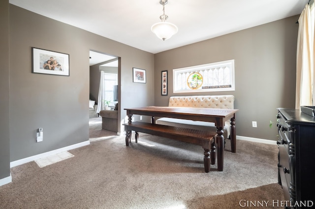 carpeted dining area with baseboards