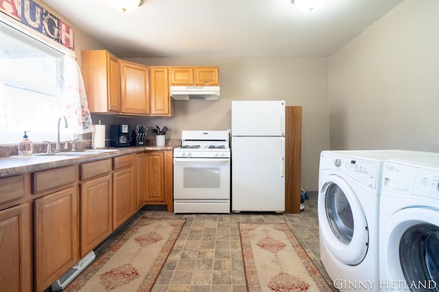 kitchen featuring under cabinet range hood, a sink, washing machine and dryer, white appliances, and light countertops