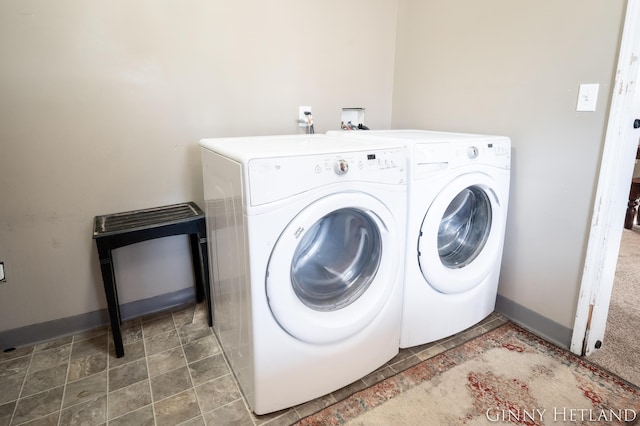 washroom featuring baseboards, independent washer and dryer, and laundry area