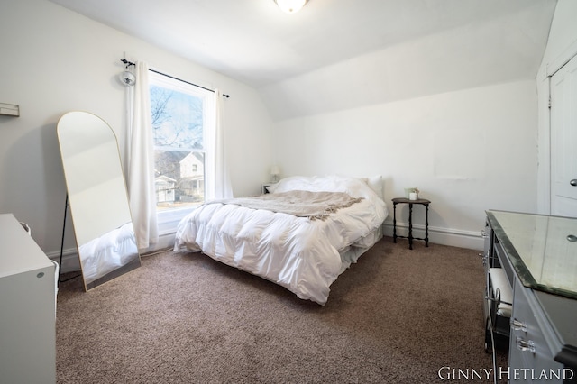 bedroom with vaulted ceiling, baseboards, and carpet floors