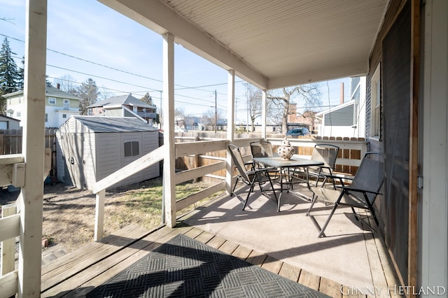 exterior space featuring a storage shed, outdoor dining area, a residential view, and an outdoor structure