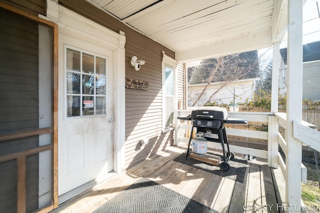 deck with a porch and a grill