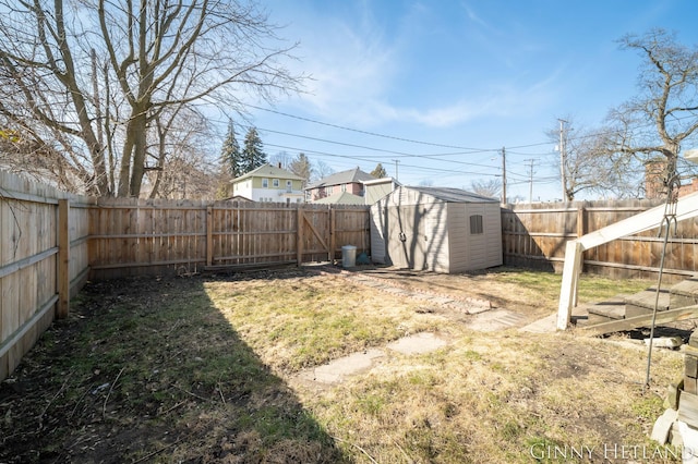 view of yard featuring an outdoor structure, a storage unit, and a fenced backyard