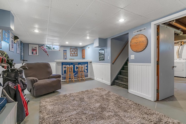 interior space with visible vents, washer / dryer, stairs, wainscoting, and a dry bar