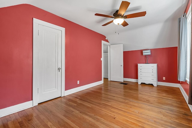 additional living space with baseboards, lofted ceiling, and light wood-style floors